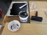 ゴムローラーの乗っている黄味の板でシリコーン原液が塗ってある。この板にインクが付いてもローラーを転がせば綺麗にとれる。
